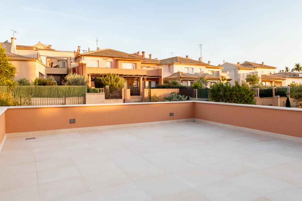 Terraza recién construida en una vivienda de Guillena con pavimento claro y zona exterior preparada para el verano